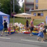 Lastefestivali laat, kus palju inimesi, mänguasju ja müüjaid.