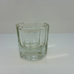 Väike klaastopsik kulmu ja ripsmevärvide segamiseks laua peal.