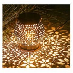 Päikeseenergial töötav lillemustriga valguskera valgustatuna.