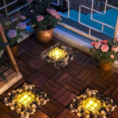 Solar lkaasist neljakandilised lambid valgustamas,mis on asetatud aeda kivide vahele.