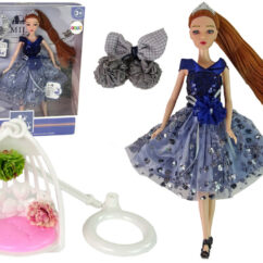 Ilus pruunide pikkade juustega nukk, tumesinises litritega kleidis. Jalas on mustad kingad ja pildil on veel valge luksusliku välimusega kiik.