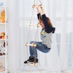 Poiss ronimas puidust pulkadega köisredelil toas.