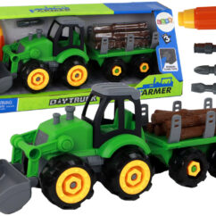 Laste roheline traktor ees kopa ja järelkäruga, millel on pruunid palgid. Kaasas on kruvikeeraja koos otsikutega.