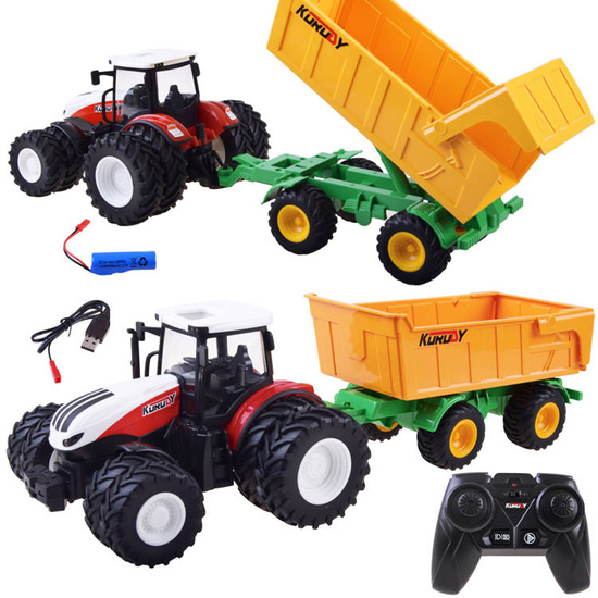 Mängutraktor järelkäru ja puldiga. Traktoril on kollane käru ja suured kummist topeltrattad.