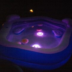 Bassein koos lillas toonis veekindlate lampudega hämaras.