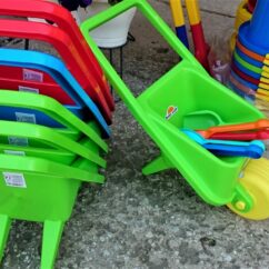 Roheline laste aiakäru koos liivakasti kühvlitega.