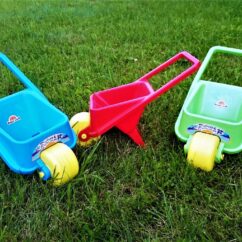 Väiksed laste aiakärud sinine, roheline ja punane muruplatsil