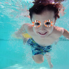 Laps ujumas vee all kala temaatikaga oranžide ujumisprillidega.