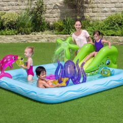Täispuhutav laste veemänguväljak koos liumäe ja mereloomadega, koos lastega muruplatsil.