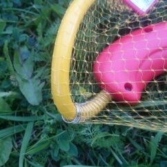 Veepüstol muruplatsil, millel on vooliku ühenduste koht kinnitatud vedruga.